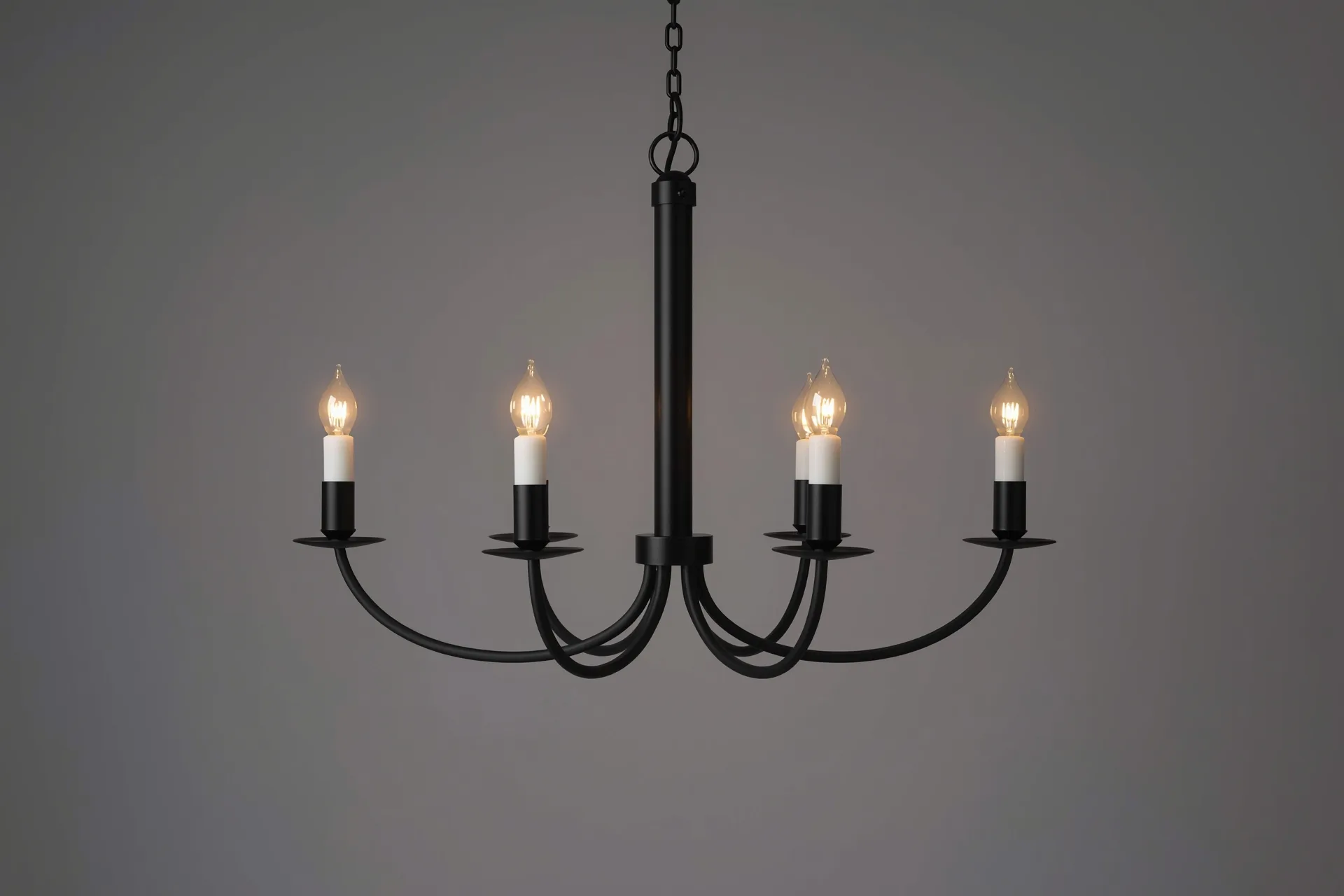 Five-light black candle-style chandelier on a matched chain against seamless warm grey, bulbs lit low, frame crisp